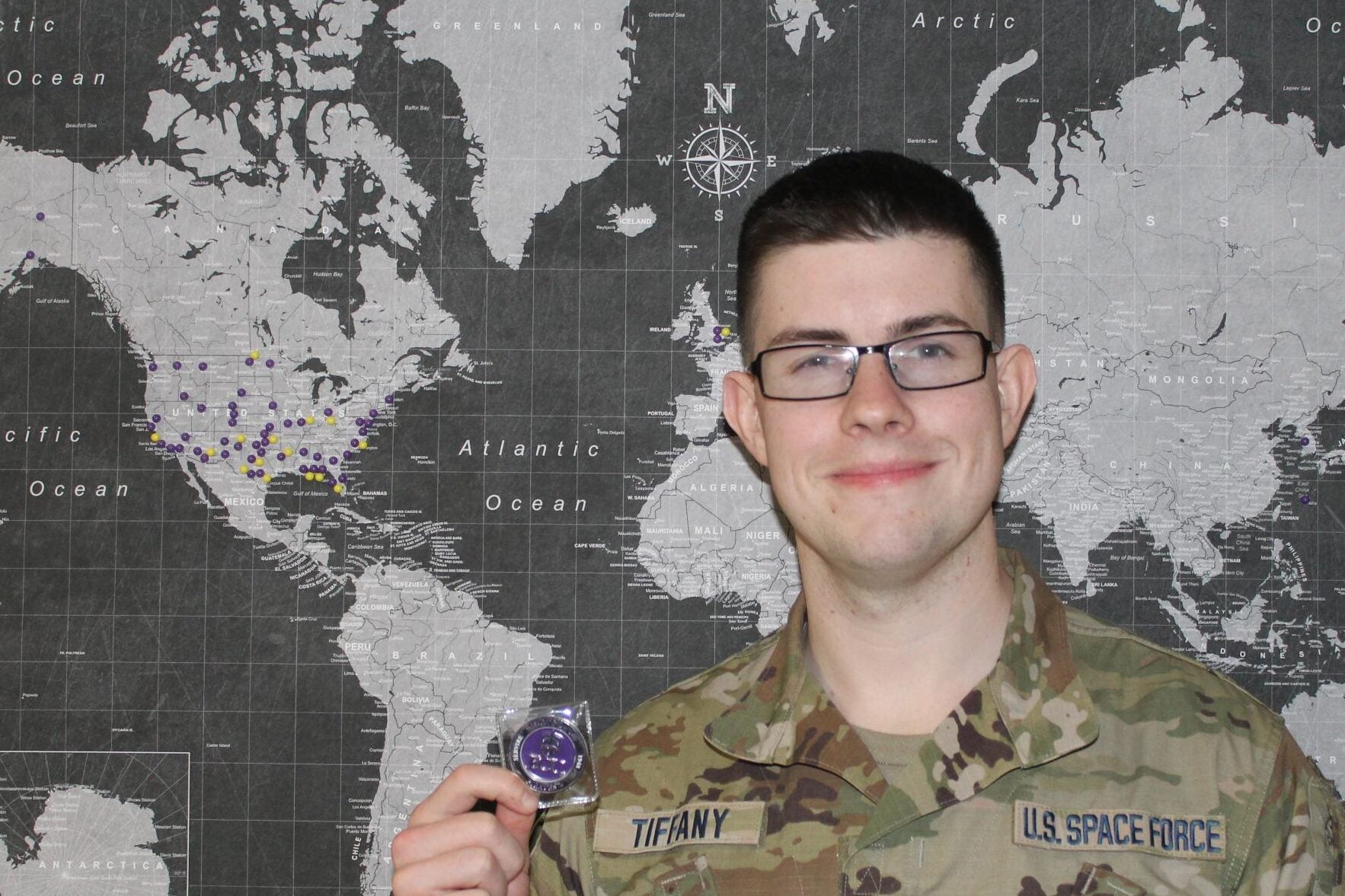 A photo of United States Space Force Cadet Caleb Tiffany holding his commanders coin for having received the award of Cadet of the Month.